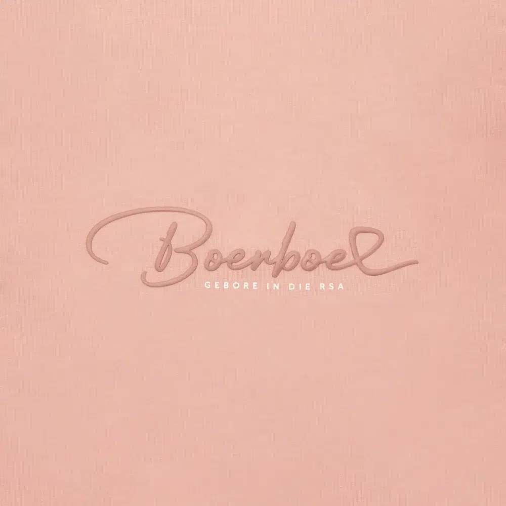 Close-up of tonal Boerboel embossed logo on light pink CANSA t-shirt showing Boerboel Gebore in die RSA text